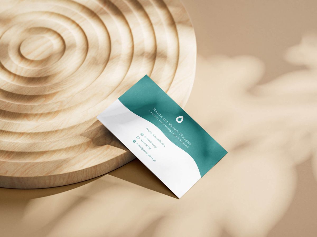 Detalhe do cartão de visita Almond Tree Therapies com símbolo da amêndoa e tagline Energy balancing, anywhere